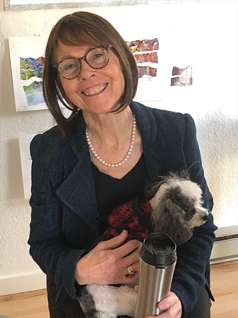 smiling woman holding small fluffy dog